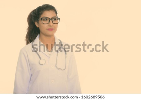 Studio shot of young beautiful Persian woman doctor thinking with eyeglasses isolated against white background