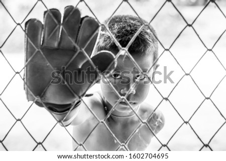 little boy soccer goalkeeper with gloves,Sport concept black and white picture.