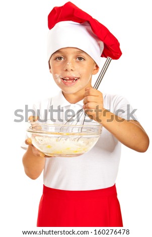 Cheerful chef boy mixing ingredients in a bowl