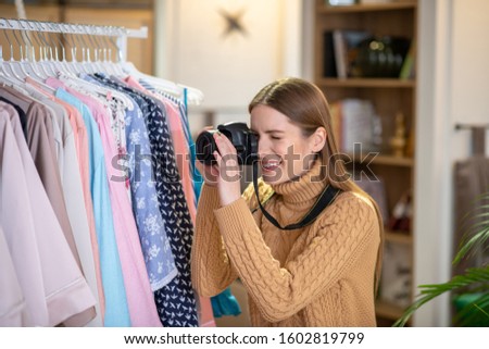 Attractive pictures. A woman taking pictures of clothes for online shop