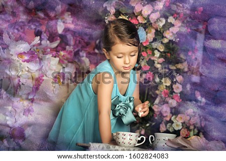 Beautiful Little girl in a smart dress around the table with tea and marshmallow