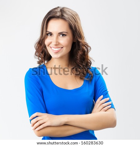 Portrait of young cheerful smiling woman, over grey background Royalty-Free Stock Photo #160283630