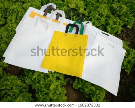 Reusable Non woven Bags isolate on green background. Eco Friendly Polypropylene Shopping Bags, Environment Friendly Concept. Reduce, Reuse, Recycle, save earth