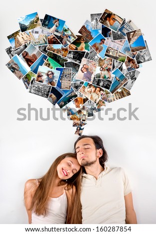 Young couple dreaming about their love and travel with heart shape made from photo cards