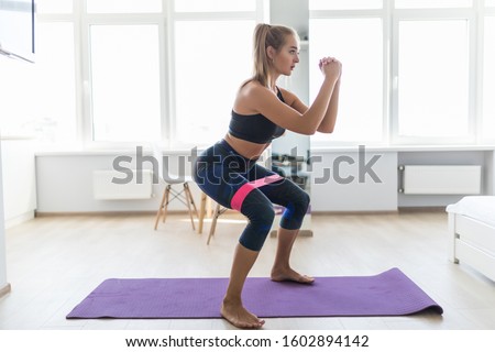 Woman during her fitness workout at home with rubber resistance band Royalty-Free Stock Photo #1602894142