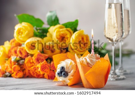 Cupcakes, champagne and flowers on a bright background. Valentine day holiday concept