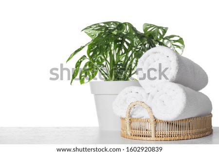 Fresh bath towels on table against white background