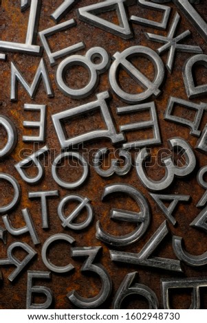 Backgrounds and textures: assorted metal cyrillic letters on a rusty background, typographic art abstract