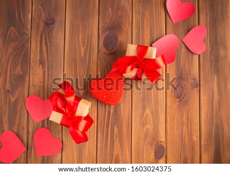 Red hearts and gifts on a wooden background. Valentine's Day Gift
