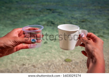 ecology concept, the fight against plastic, in female hands two glasses - plastic and paper