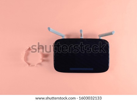 Wi-Fi router on pink background with torn hole