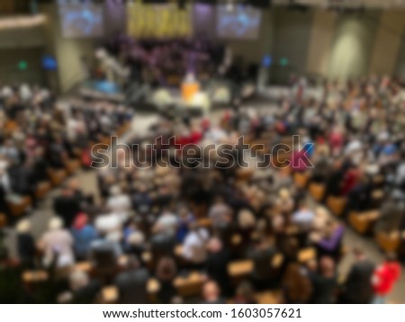 Abstract blur of a full mega church indoors. Royalty-Free Stock Photo #1603057621