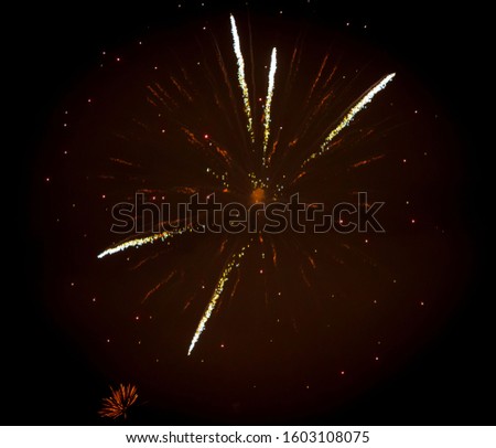 Beautiful lights fireworks exploding in night black sky. Holiday festival style. Pyrotechnics amazing background. Celebration abstract fire.