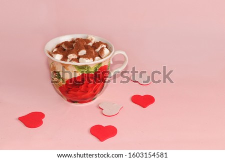 Cup of cocoa with marshmallows and hearts on a pink background. Wishes good morning and have a nice day, the atmosphere of winter holidays
