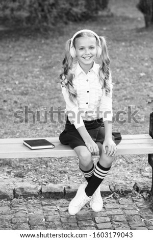 Enrich your life. schoolgirl in classy retro uniform listen audio book. old school music. back to school. using headset technology. small happy girl listen e-book. e-learning. vintage kid fashion.