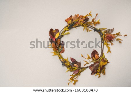 Top view of horizontal image of autumn wreath made with real tree leaves on an isolated background.