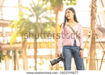 Young Asian traveler woman smiling while taking photo on holidays vacation.