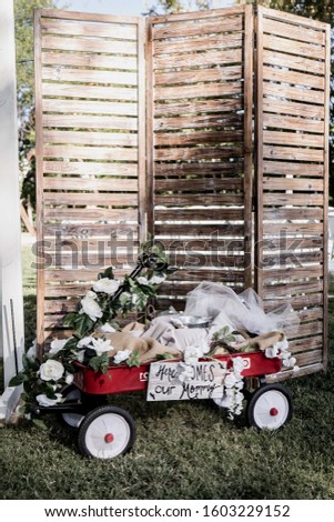 A red wagon at a wedding with flowers and a cute backdrop 