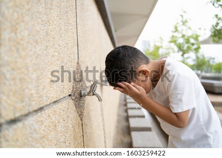 Muslim Kid takes ablution before 
 perform a prayer Royalty-Free Stock Photo #1603259422