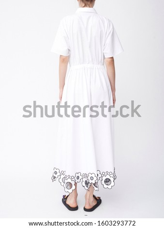 Beautiful white long dress for women’s paired with black sleepers and white background,..