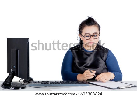 Portrait of beautiful Asian businesswoman wearing formal attire while writing her job assignments, isolated in white background