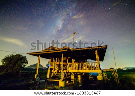 Milky Way Galaxy and star over one traditional malay house at mid Night. Long exposure photograph, with grain.Image contain certain grain or noise and soft focus.