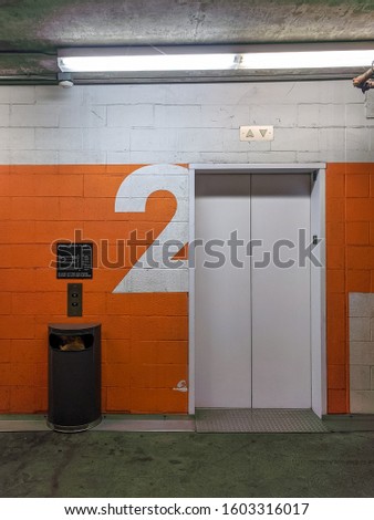 Frontal shot of 2nd floor elevator entrance surrounded in an industrial/grungy environment
