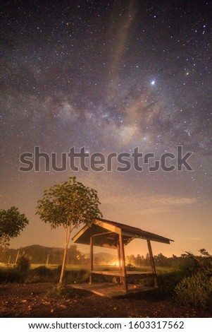 Milky Way behind over farmer's hut in rice field.