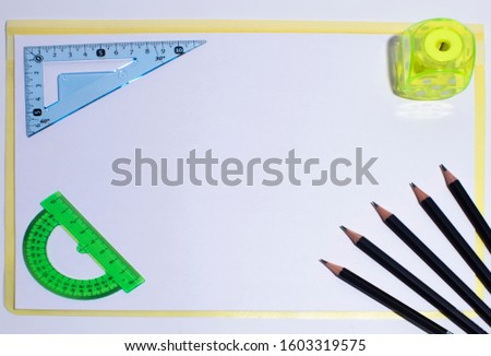 Blue plastic corner ruler five black pencils protractor and sharpener with
copy space.