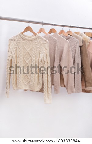 Row of various Different clothes with knitted sweater with jacket, fur, coat on hanger


