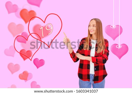 Beautiful Happy Young woman points to Valentines Day.  Valentines Day concept.