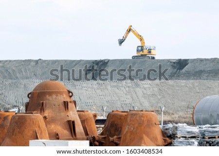 The excavator is working in the construction site. Excavators (hydraulic) are heavy construction equipment consisting of a boom, dipper (or stick), bucket and cab on a rotating platform.