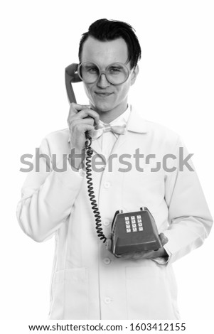 Studio shot of young crazy man doctor holding old telephone