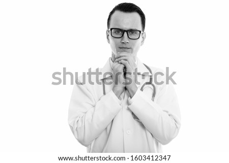 Studio shot of young worried man doctor looking at camera