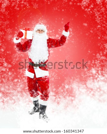 Santa Claus hold gift box present point finger glove up at copy space over red christmas background abstract winter snow, concept of christmas new year sale shopping