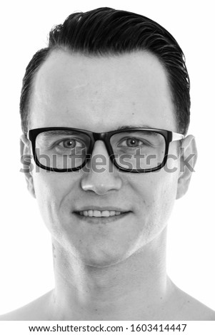 Face of young happy man smiling while wearing eyeglasses