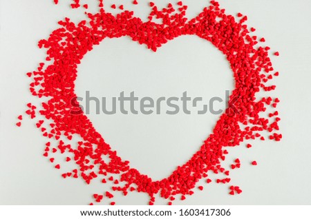 Valentines day love background. Red sugar hearts in the shape of a big heart. Creeting card for Valentines Day. Copy space, top view. Horizontal orientation.