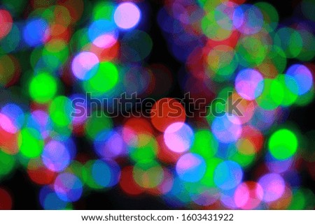 Christmas or New Year defocused lights, bokeh background. Beautiful blurred circles of green, blue, red colors on black background, winter holidays concept