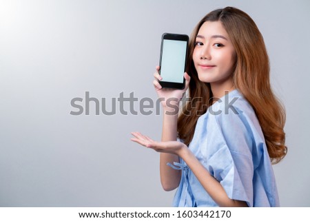 business healthy insurance beautiful asian female in hospital uniform smile with hand show blank screen smartphone ideas for happy insurance package and promotion with hospital blur background