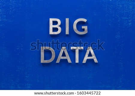 the words big data laid with silver metal characters on blue painted wooden board in central flat lay composition
