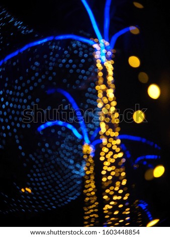 colourful defocused decorative light bulbs on palm tree garden in an unidentified city center during Christmas and new year ceremony festival at night for backdrop background use 
