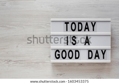 'Today is a good day' words on a modern board on a white wooden surface, top view. Overhead, from above, flat lay. Space for text.