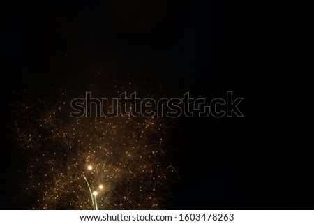Beautiful colorful bright fireworks on the black sky background during new year evening celebration