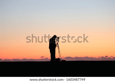 Photographer shooting sunset view at the seaside.