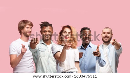Portrait of multiethnic group of young people isolated on pink studio background, flyer, collage. Concept of human emotions, facial expression, sales, advertising. Pointing on, choosing, smiling.