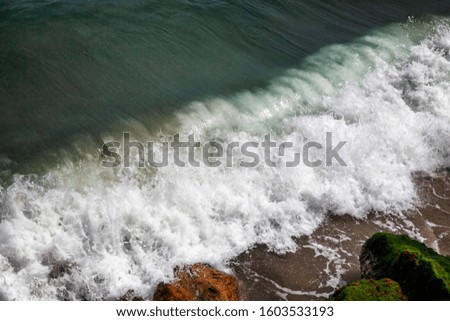 Powerful turquoise wave on a rocky shore. Close-up. Space for text. Top view. Background.