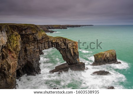 The Green Bridge of Wales. A dramatic, coastal rock arch, located on the Pembrokeshire coastline, in South Wales. Royalty-Free Stock Photo #1603538935