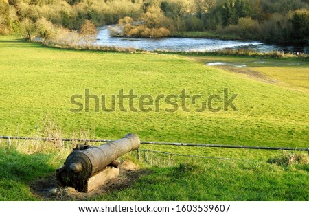 Old cannon pointing over a field towards the River Boyne in Slane, County Meath, Ireland. 