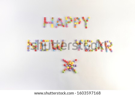 Happy New Year written with colourful glazed candy beans in capital letters