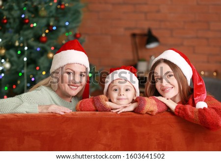 Young woman with her little daughter and mother on Christmas eve at home